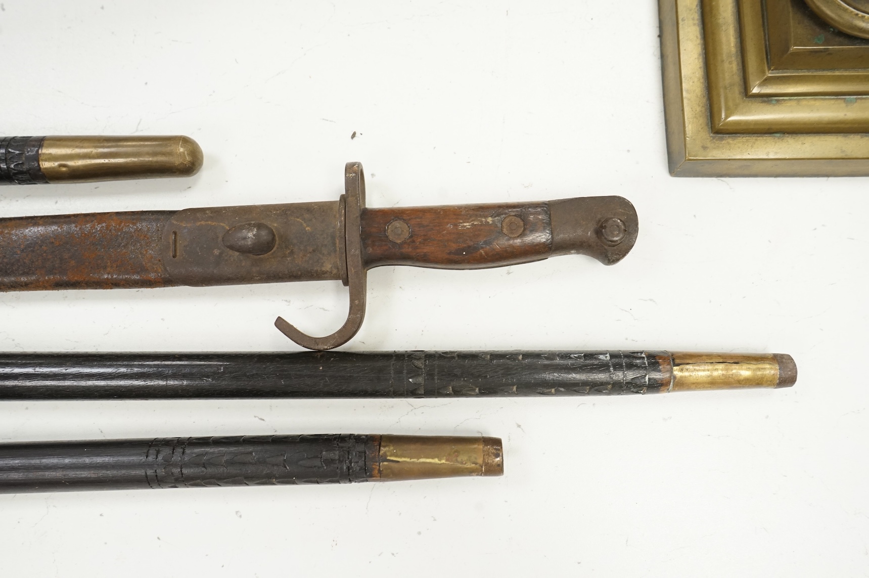 Three early 20th century Indonesian bone overlaid sword sticks and a bayonet, largest 92cm in length